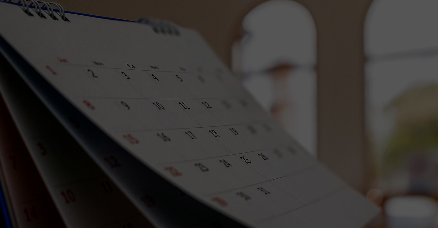 Close up white paper desk calendar with blurred bokeh background appointment and business meeting concept