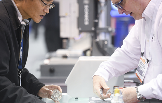 Two men examining a product in the expo hall floor